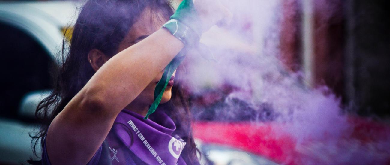 purple smoke around woman at protest